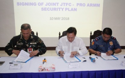 <p><strong>SECURITY MOA.</strong> Commission on Elections - Autonomous Region in Muslim Mindanao Director Ray Sumalipao is flanked by Lieutenant Gen. Arnel dela Vega, Army 6th Infantry Division and Joint Task Force Central commander (left) and Chief Supt. Graciano Mijares, ARMM police director (right), in signing Thursday (May 10) a joint security plan for Maguindanao and Lanao del Sur provinces in connection with the May 14 barangay and Sangguniang Kabataan polls. <em><strong>(Photo by 6ID)</strong></em></p>